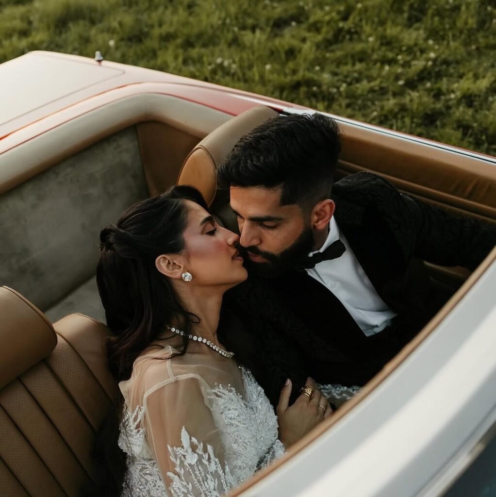 Groom wearing black wedding tuxedo and is pictured in his car with his bride