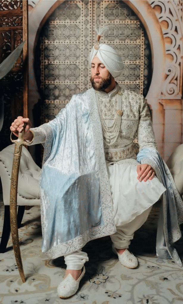 Groom in White Maharaja Sherwani with a sword