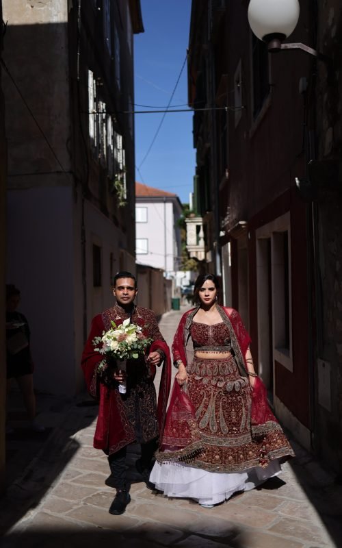 Couple in red maharaja sherwani and lehenga